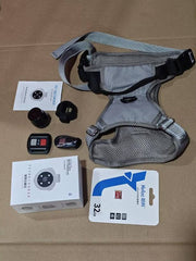 Grey pet recorder collar with GPS, camera accessories, remote control, and 32GB memory card on brown surface
